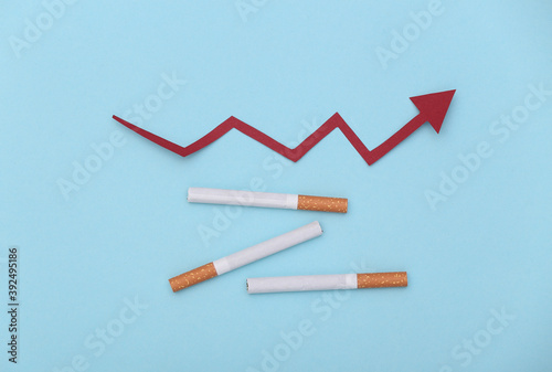 Cigarettes and upward growth arrow on blue background