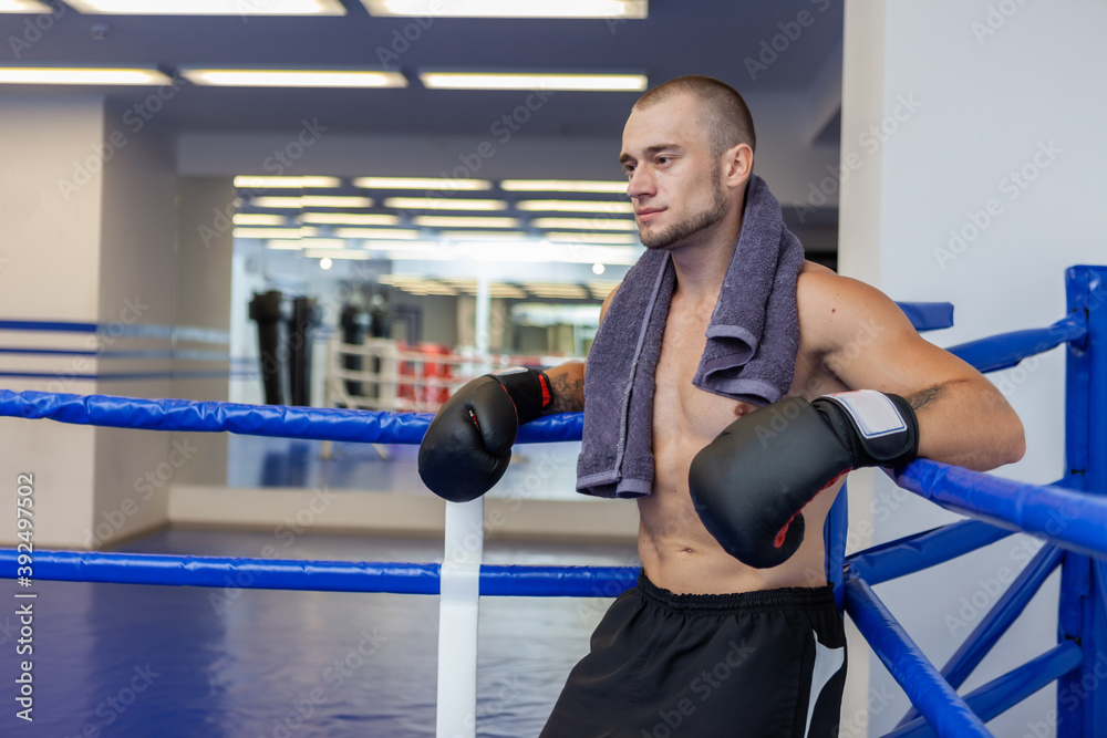 Portrait of a tired male boxer in a boxing ring