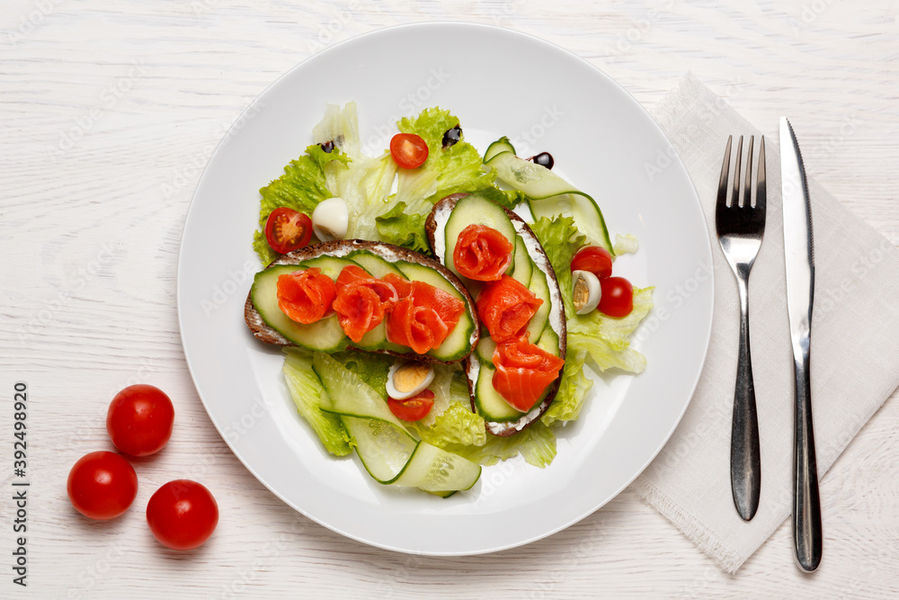 Norwegian Breakfast consisting of salmon and cucumber sandwiches, lettuce leaves and an egg