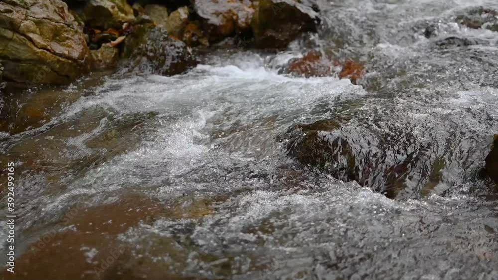 Low angle view of small stream flows over rocky cascades. Fresh and clean water in nature. Static shot, slow motion, close up Low angle view of small stream flows over rocky cascades. Fresh and clean water in nature. Static shot, slow motion, close up