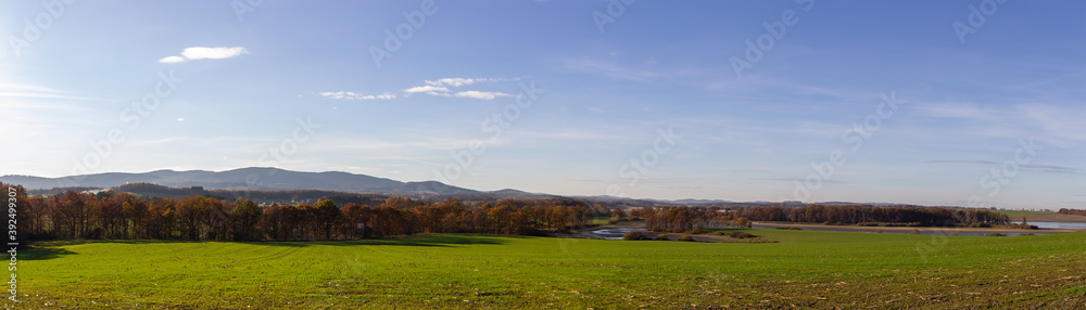 Panoramic view to Czech autumn landscape. Dry pond Dehtar with meadow, trees and distant hill at day time