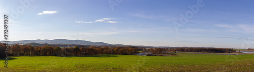 Panoramic view to Czech autumn landscape. Dry pond Dehtar with meadow, trees and distant hill at day time
