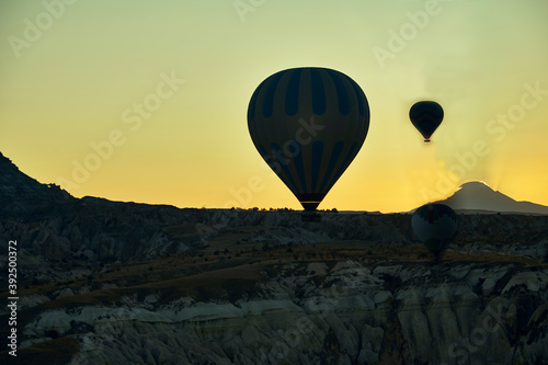 Silhouette of hot air balloon flying over the valley at Cappadocia, Anatolia, Turkey. Volcanic mountains in Goreme national park.