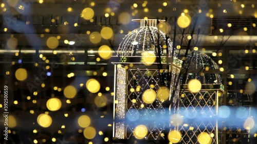 Christmas and New Year holidays illumination outdoor in city street at night. Golden shimmering and waving garlands and luminous kiosk.blinking lights from garlands