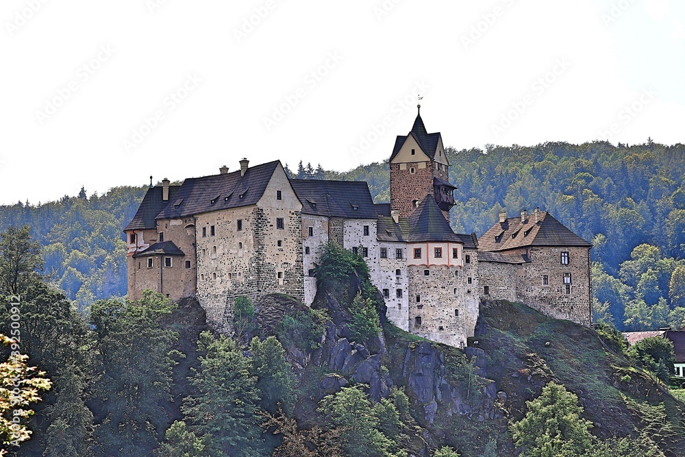 a dilapidated castle on top of a high cliff above the river