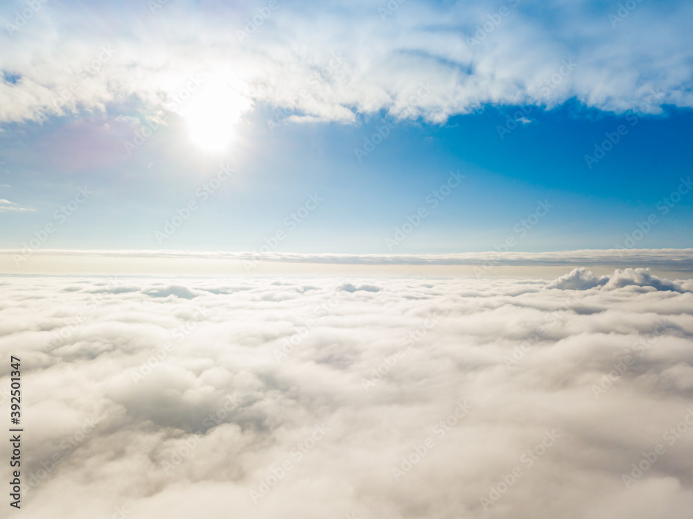 Aerial view. Flying over white clouds during the day in sunny weather.
