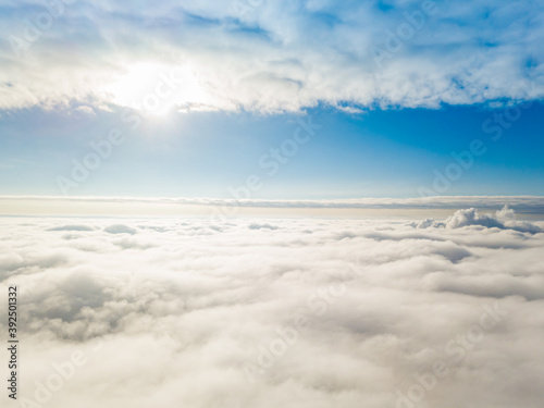 Aerial view. Flying over white clouds during the day in sunny weather.