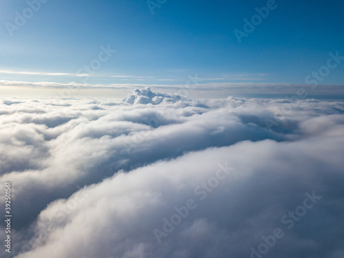 Aerial view. Flying over white clouds during the day in sunny weather.