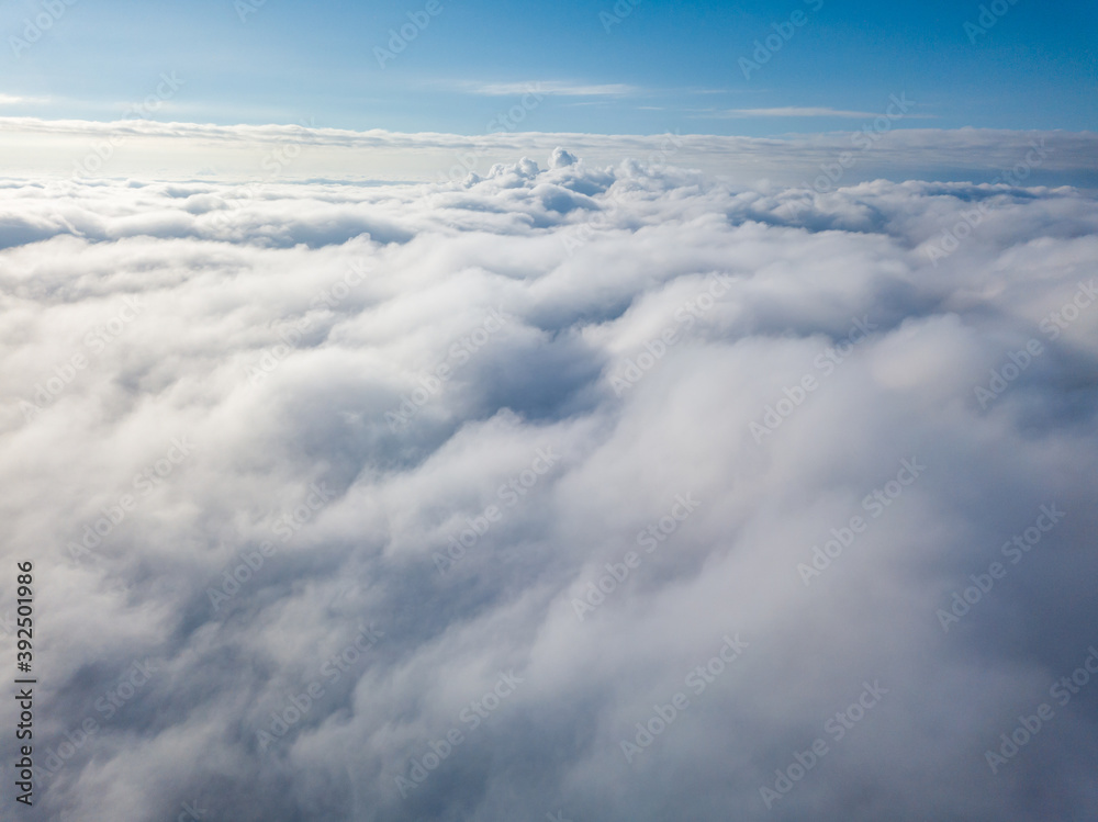 Aerial view. Flying over white clouds during the day in sunny weather. Aerial view. Flying over white clouds during the day in sunny weather.