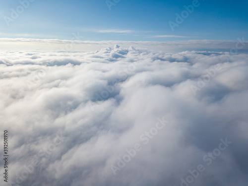 Aerial view. Flying over white clouds during the day in sunny weather.