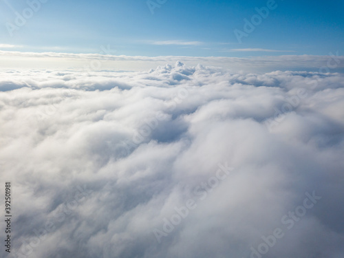 Aerial view. Flying over white clouds during the day in sunny weather.