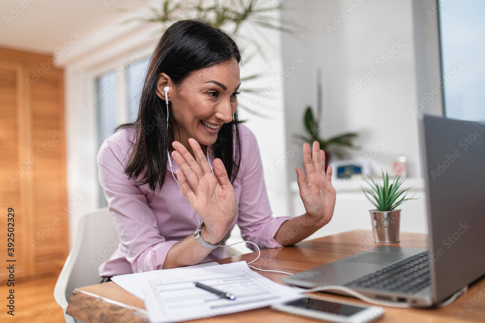 Attractive and happy middle age female freelancer is working from home during Coronavirus or Covid-19 lockdown or quarantine. Social distancing and freelancing job concept. Attractive and happy middle age female freelancer is working from home during Coronavirus or Covid-19 lockdown or quarantine. Social distancing and freelancing job concept.