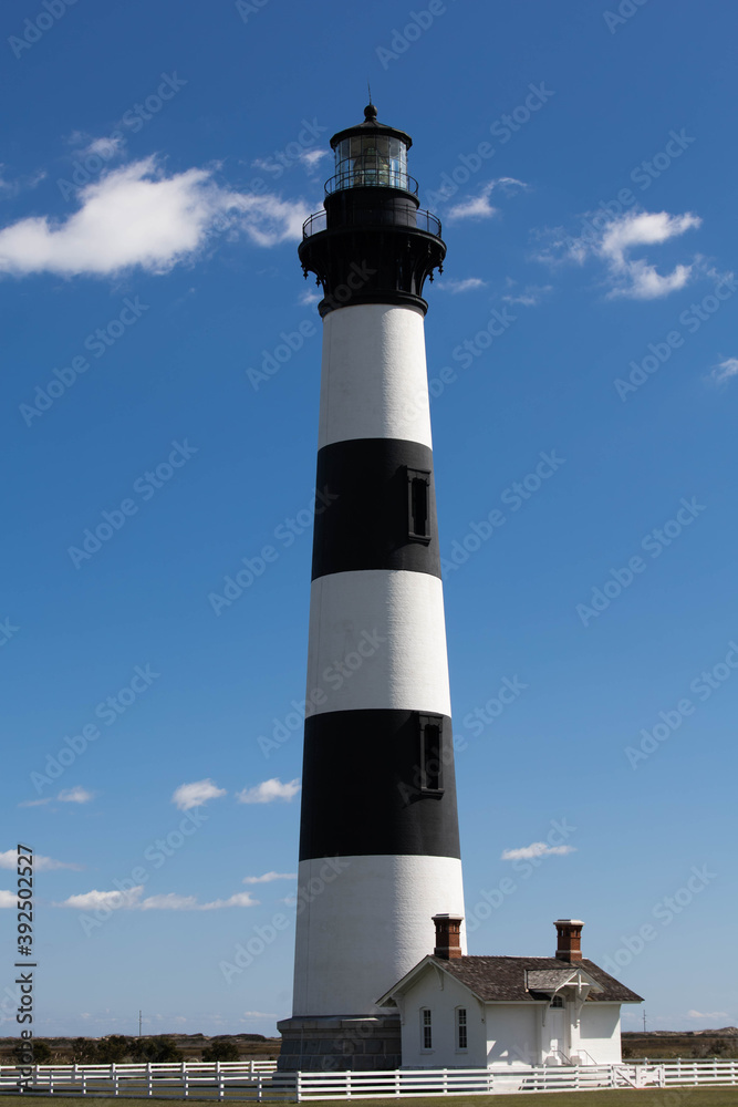 Bodie Island Lighthouse near Nags Head, NC in the Outer Banks of North Carolina with beautiful blue sky and soft white clouds in background. Hatteras National Seashore.