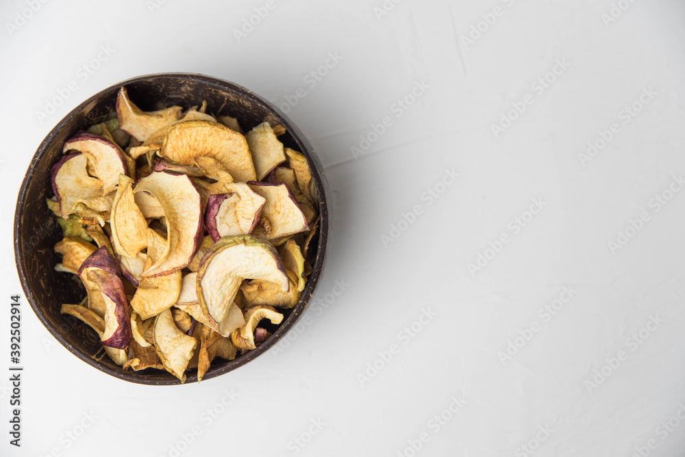 Homemade crispy sun dried organic apple slices. Close up of apple chips with spice in bowl isolated on white background with copy space for text Homemade crispy sun dried organic apple slices. Close up of apple chips with spice in bowl isolated on white background with copy space for text