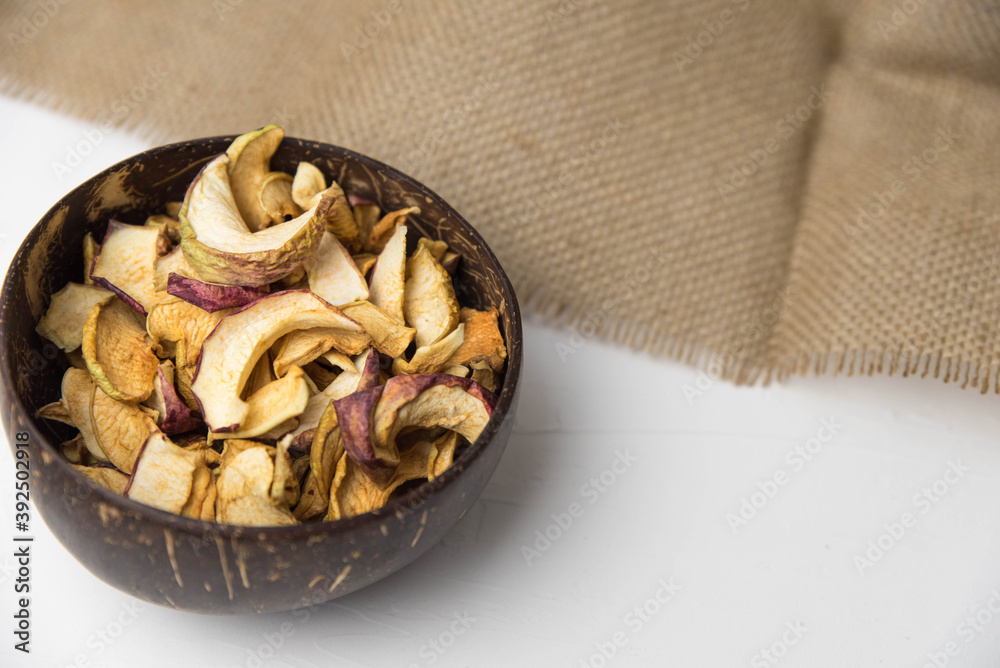 Homemade crispy sun dried organic apple slices. Close up of apple chips with spice in bowl isolated on white background with copy space for text Homemade crispy sun dried organic apple slices. Close up of apple chips with spice in bowl isolated on white background with copy space for text