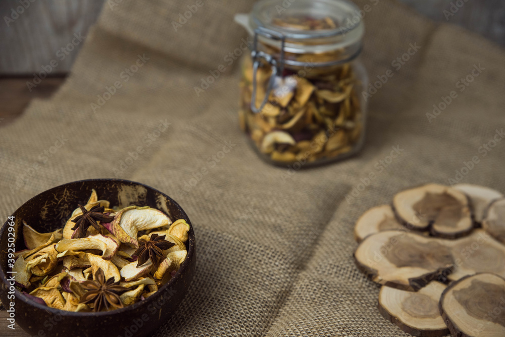 Homemade crispy sun dried organic apple slices. Close up of apple chips with spice in bowl on brown wooden background with copy space for text Homemade crispy sun dried organic apple slices. Close up of apple chips with spice in bowl on brown wooden background with copy space for text