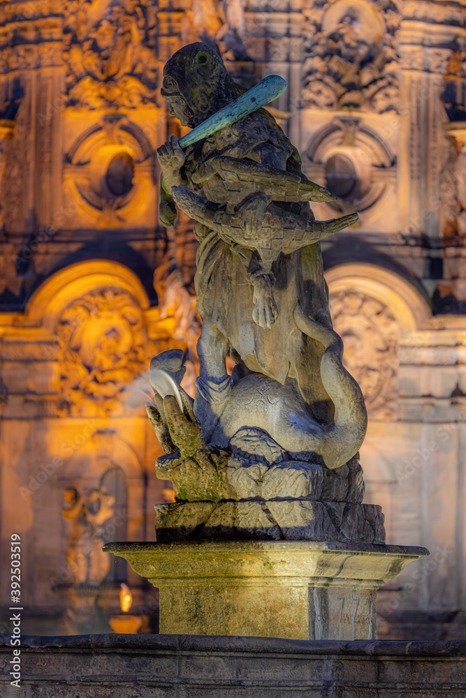 Statue of Hercules standing on a fountain in Olomouc. In the background, the column of the Holy Trinity, written in UNESCO