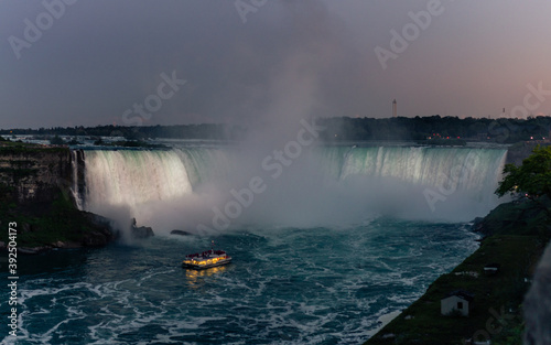 Close up view of Niagara falls in night with tourist bout at the bottom of falls, shooted from Canadien side