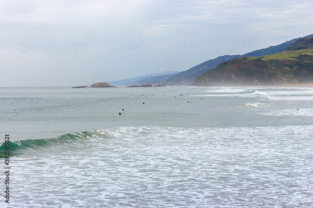 10/12/2019 - Spain: Surfers in waves. Surfers and waves crashing on beach. Swimmers in water on aerial seascape background. Active lifestyle. Extreme sport. Beautiful seascape with surfers. 10/12/2019 - Spain: Surfers in waves. Surfers and waves crashing on beach. Swimmers in water on aerial seascape background. Active lifestyle. Extreme sport. Beautiful seascape with surfers.