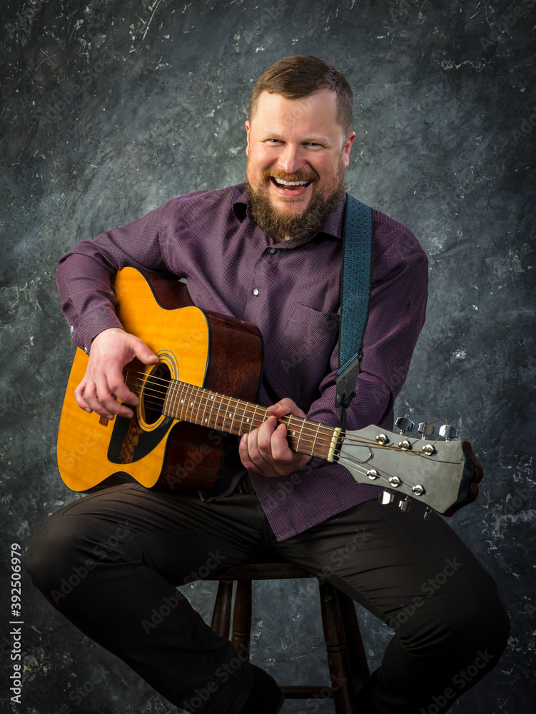 Obraz premium Mature musician plays acoustic guitar emotional studio portrait.