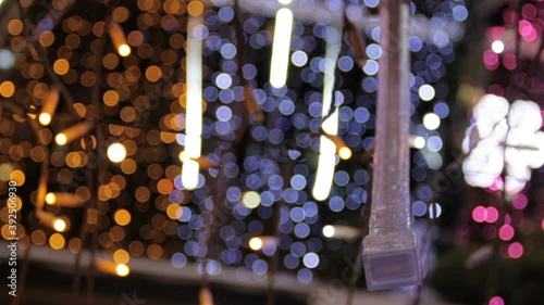 Close up of closed blinking end white led strip light in light tunnel.Christmas street decorations, new year preparation in city. Abstract blurry background.
