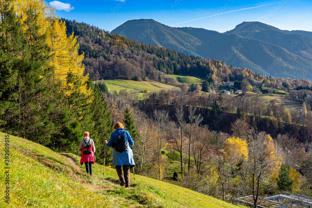 Herbst in Bayern: Zwei Seniorinnen wandern den Tegernseer Höhenweg mit Blick auf den Wallberg