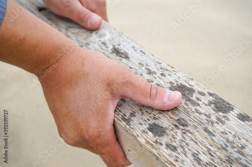men's hands hold a texture Board for finishing work on a clear day