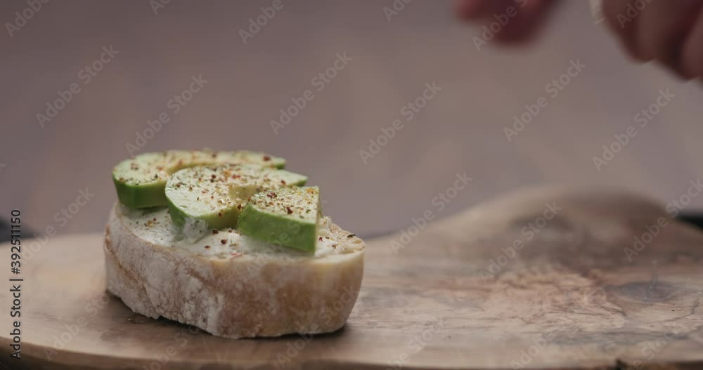Slow motion man put sandwich with avocado and cream cheese on olive board Slow motion man put sandwich with avocado and cream cheese on olive board