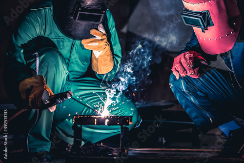 Metal welding steel works using electric arc welding machine to weld steel at factory. Metalwork manufacturing and construction maintenance service by manual skill labor concept. photo