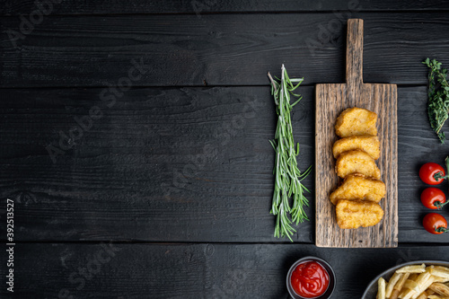Chicken breast nuggets on black wooden table, flat lay, with copy space