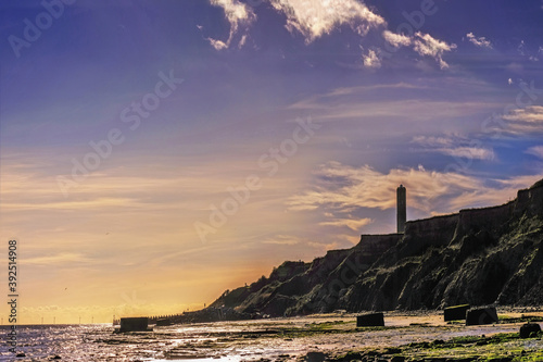 Canvas Print Prehistoric clay cliffs at Walton on the Naze, a vivid blue sky, wispy clouds, surf breaking, sun setting