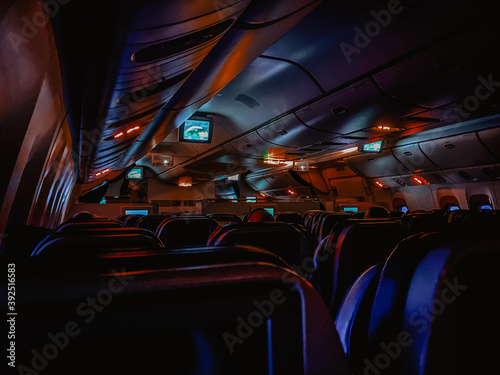 Dark aircraft cabin with red and blue lighting
