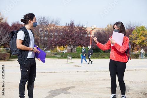 Students on university campus wearing mask keeping social distance during coronavirus