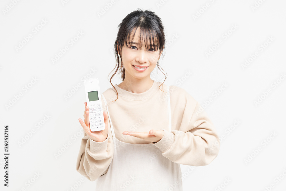 電話を手に持つ若い女性 電話を手に持つ若い女性