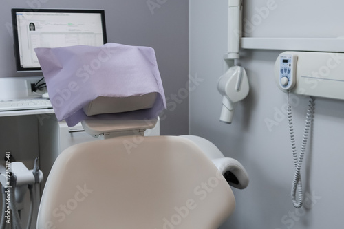dental chair in hospital.  Dental chair in a hospital with a computer in the background, close-up side view. © Nataliya