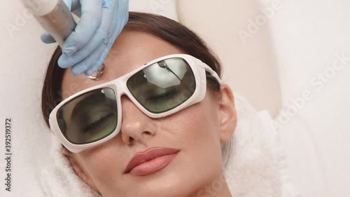 close-up of woman face receiving erbium laser treatment