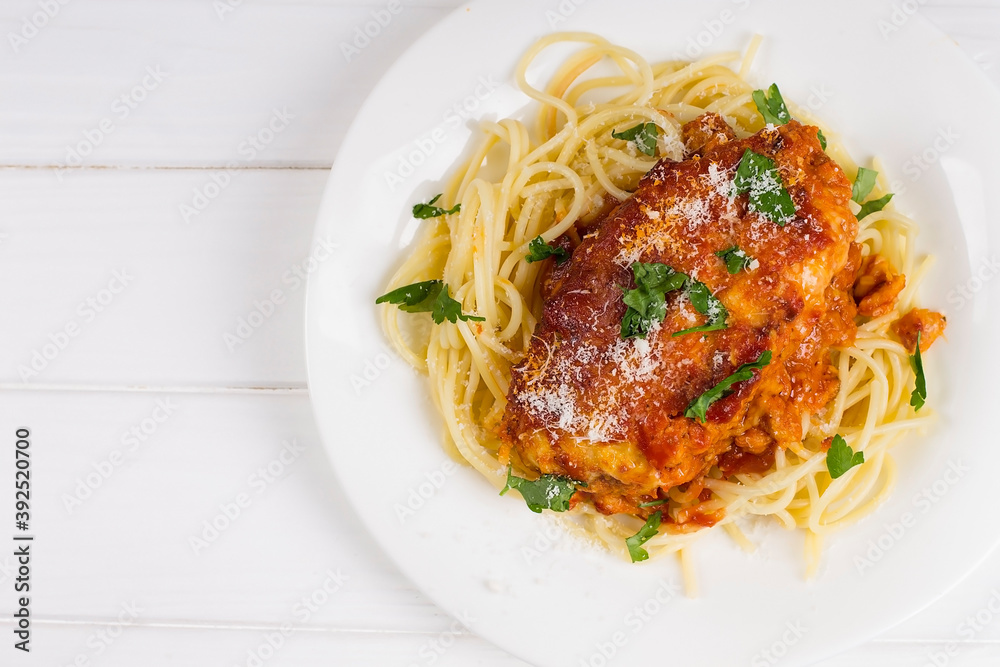 Chicken parmigiana on a white plate with spaghetti. View from above Chicken parmigiana on a white plate with spaghetti. View from above