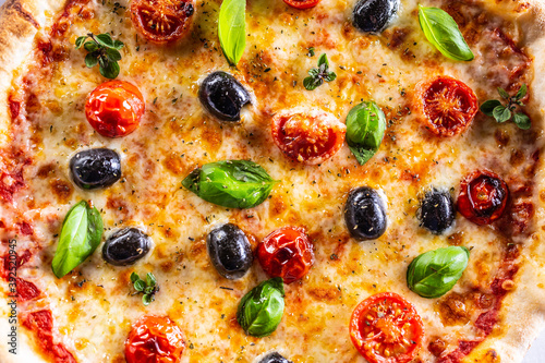 Structure pizza with tomatoes mozzarella cheese olives and basil - top pof view