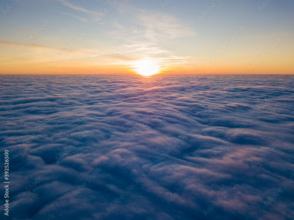 Sunset over curly clouds, aerial high flight. The last rays of the sun shine on the clouds. Sunset over curly clouds, aerial high flight. The last rays of the sun shine on the clouds.