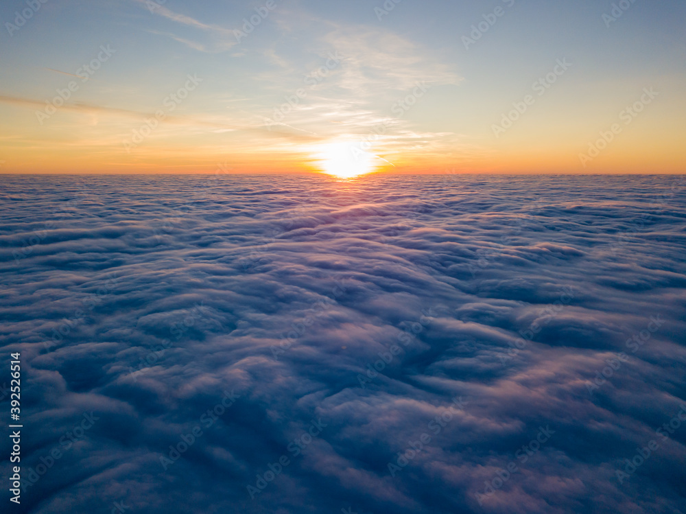 Sunset over curly clouds, aerial high flight. The last rays of the sun shine on the clouds. Sunset over curly clouds, aerial high flight. The last rays of the sun shine on the clouds.