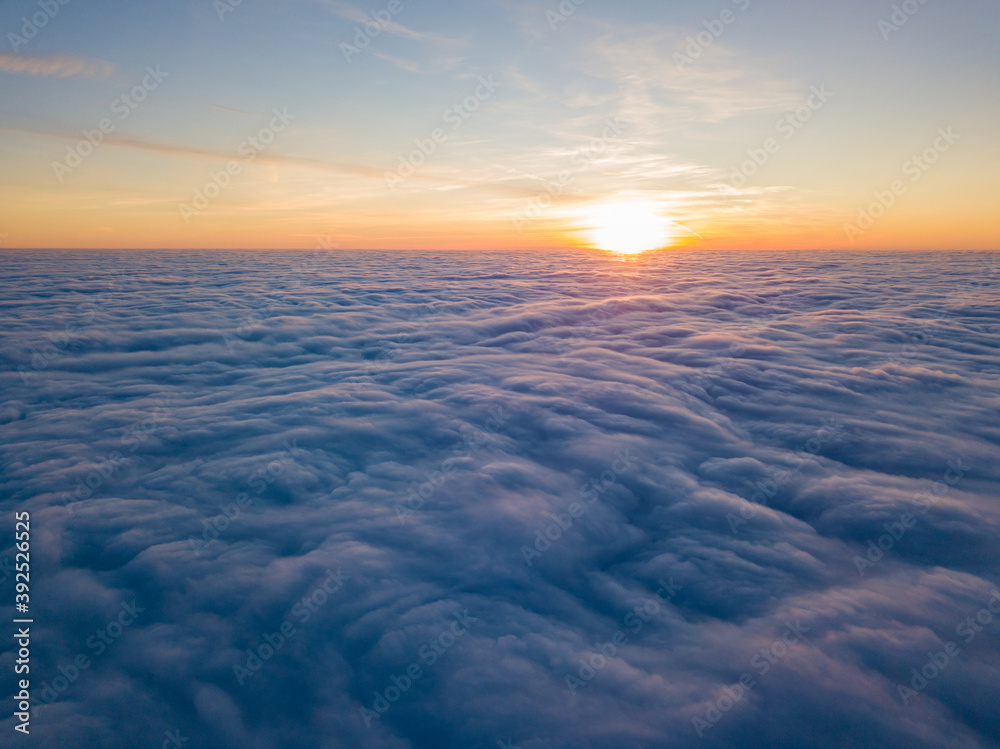 Sunset over curly clouds, aerial high flight. The last rays of the sun shine on the clouds. Sunset over curly clouds, aerial high flight. The last rays of the sun shine on the clouds.