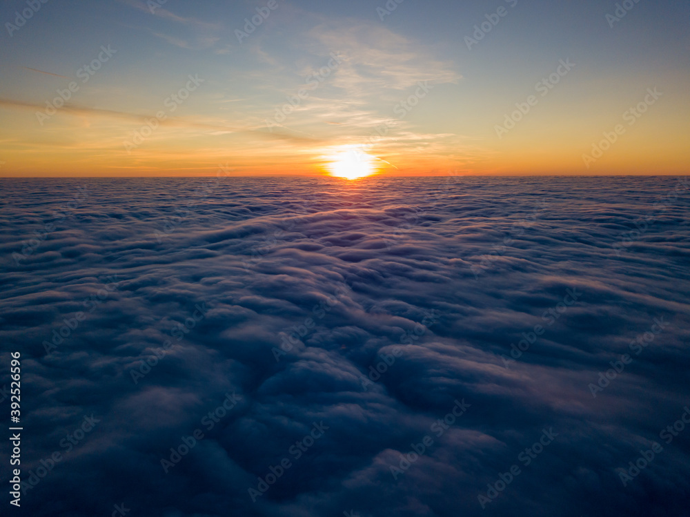 Sunset over curly clouds, aerial high flight. The last rays of the sun shine on the clouds. Sunset over curly clouds, aerial high flight. The last rays of the sun shine on the clouds.