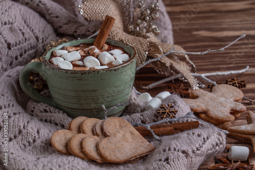 atmospheric Christmas composition, a cup of cocoa with marshmallows, gingerbread cookies, sweets, cinnamon.