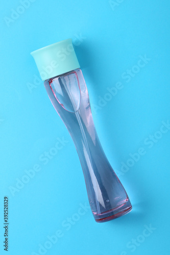 Mockup of blue fragrance perfume bottle mockup on dark empty Blue colour paper background. Top view. Horizontal