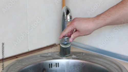 Man checking running water touching with hand. The lack of water in the tap.