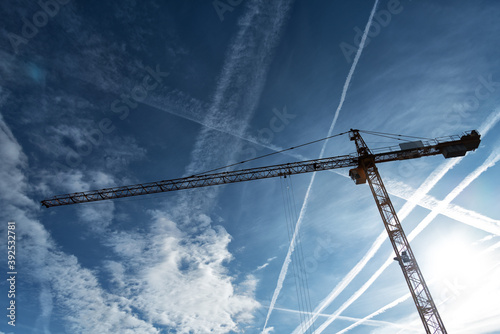 Baukran vor Himmel mit Kondensstreifen