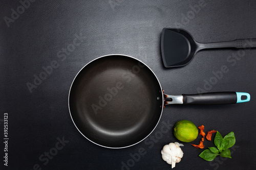 Cooking background Top view frying pan and pot on black leather table background.