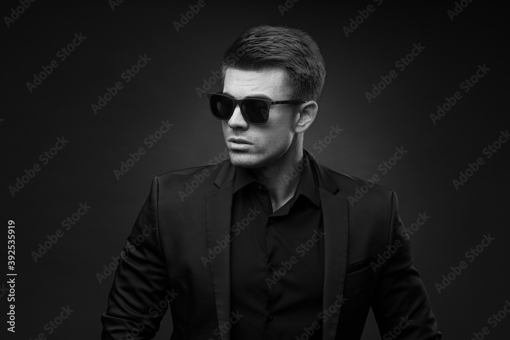 Black and white portrait of beautyful guy on dark background. High fashion model posing in studio. Attractive man in classic suit. Black and white portrait of beautyful guy on dark background. High fashion model posing in studio. Attractive man in classic suit.