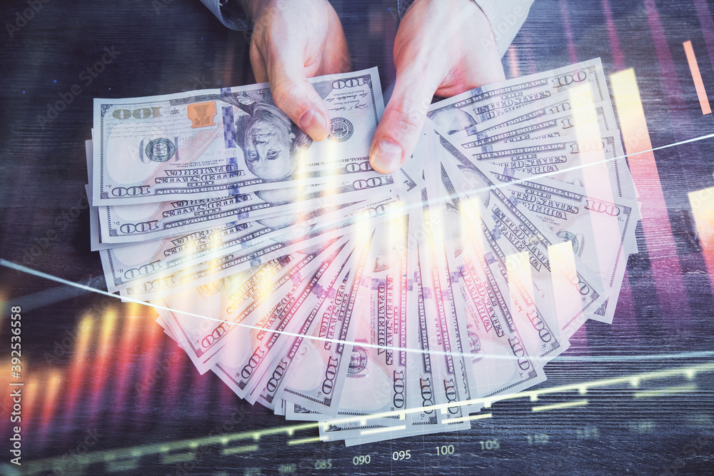 Multi exposure of financial graph drawing hologram and USA dollars bills and man hands. Analysis concept. Multi exposure of financial graph drawing hologram and USA dollars bills and man hands. Analysis concept.