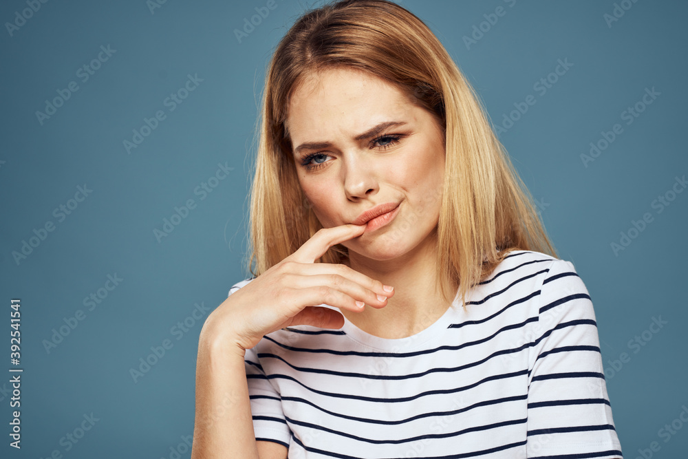 woman wearing striped t-shirt cropped view blue isolated background displeased facial expression woman wearing striped t-shirt cropped view blue isolated background displeased facial expression